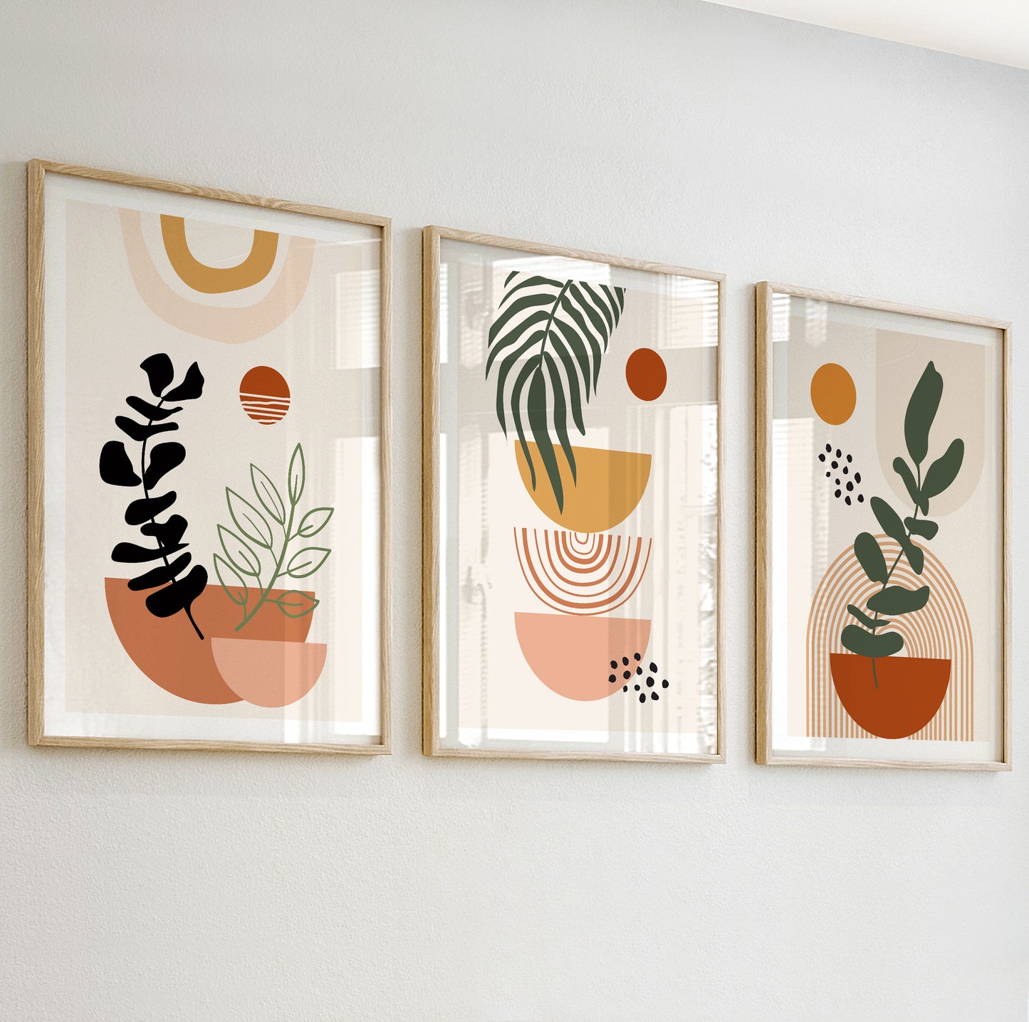 Minimalist abstract wall art with stylized black and green leaves in terracotta and peach pots.