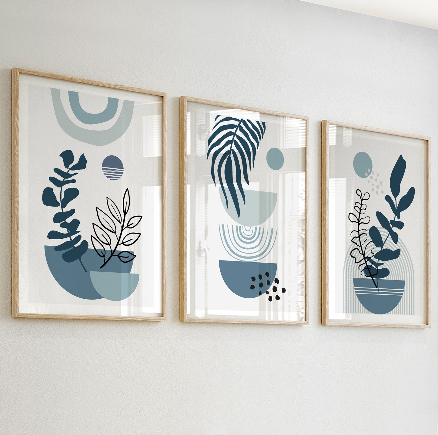 Abstract plant wall art with black and white botanical outlines in deep blue and soft teal vases.