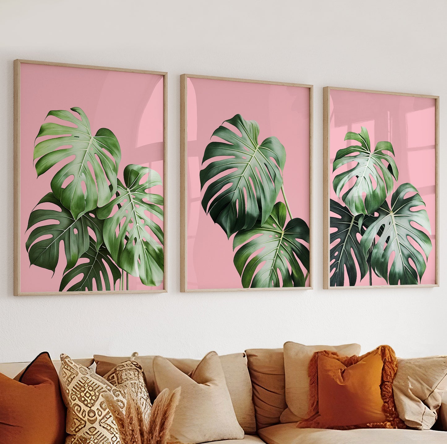 Bright central poster with detailed monstera foliage set against a solid pink background.