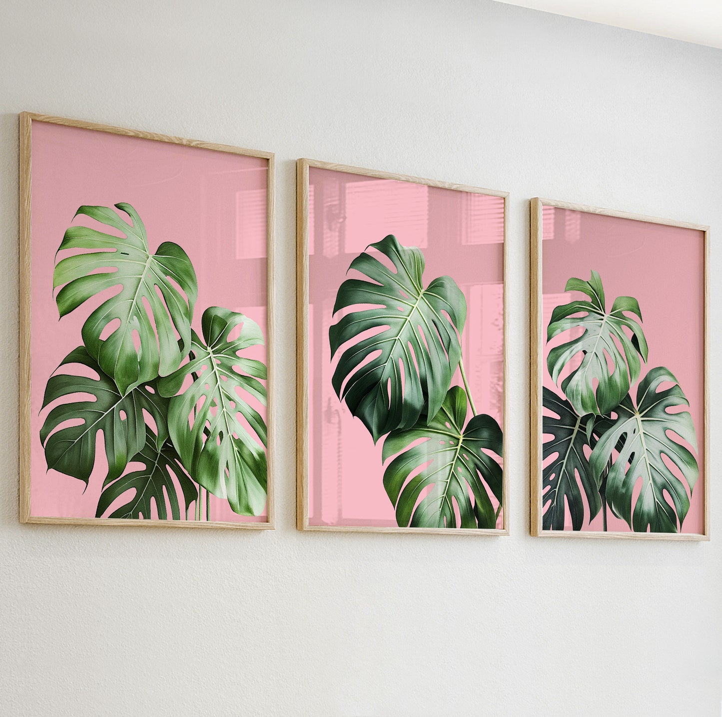 Lush monstera leaves in tropical green on soft pink background for bold wall decor.
