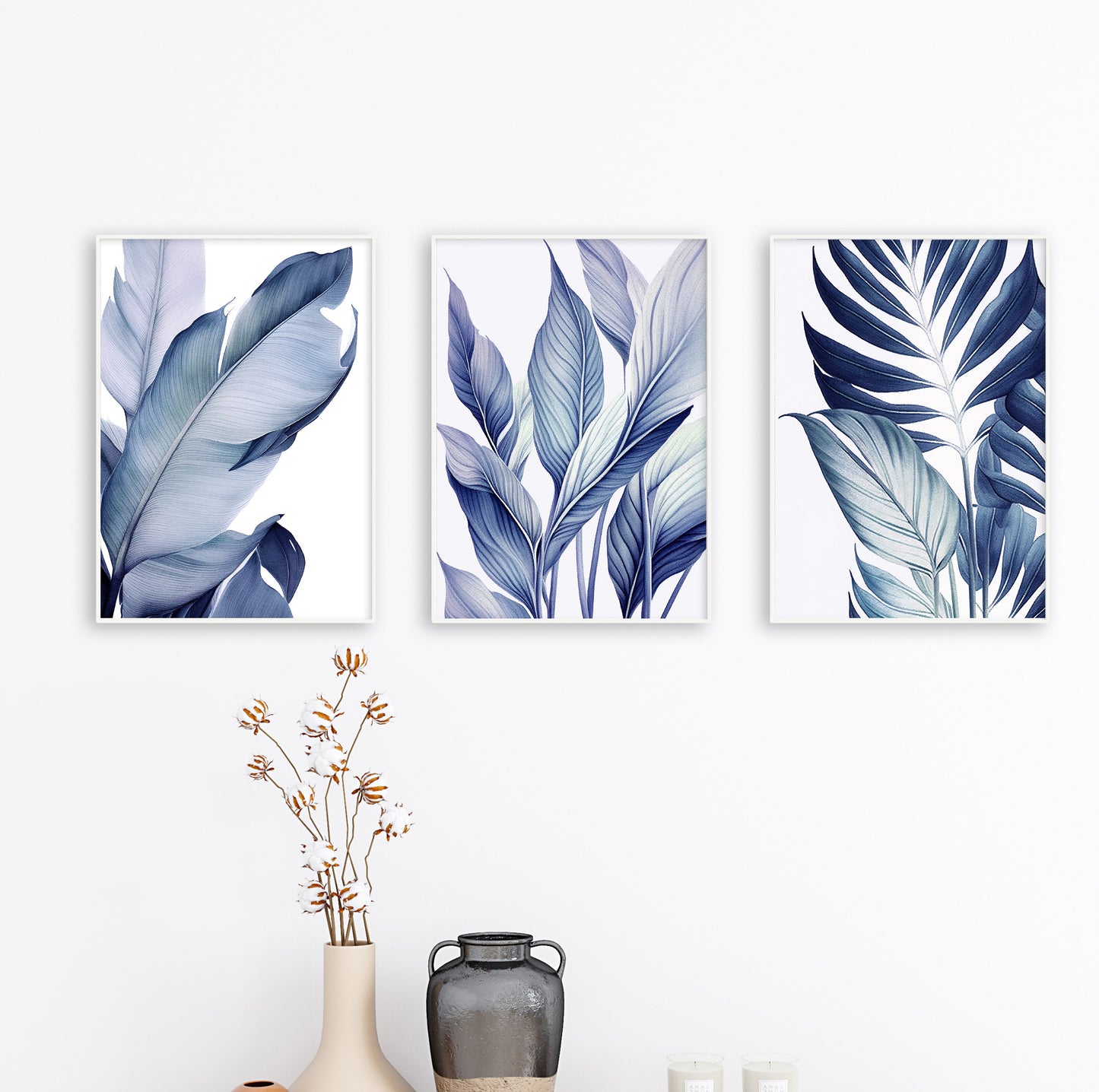 Trio of framed botanical leaf prints in blue tones arranged in a row on a light grey wall, adding harmony to the decor.