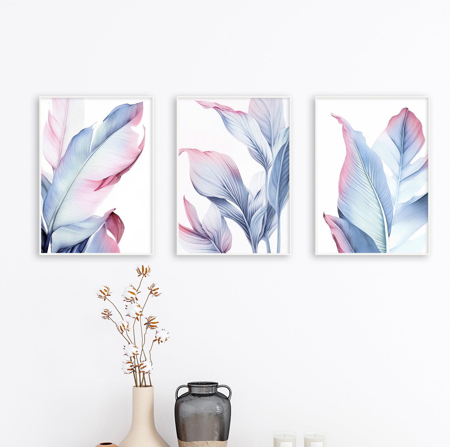 Blush and blue botanical wall art trio hanging on clean white wall in minimalist wood frames.