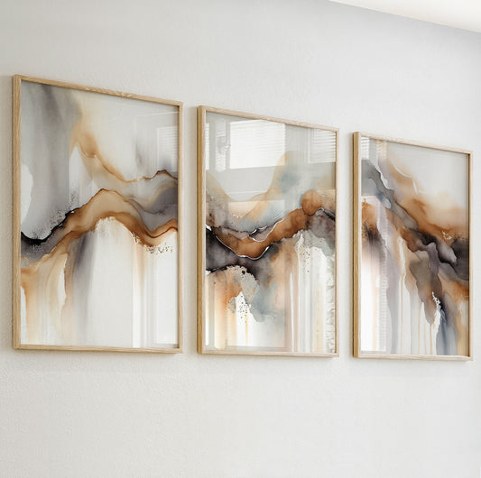 Abstract watercolor print with flowing amber and black shapes blending softly into a light background.

