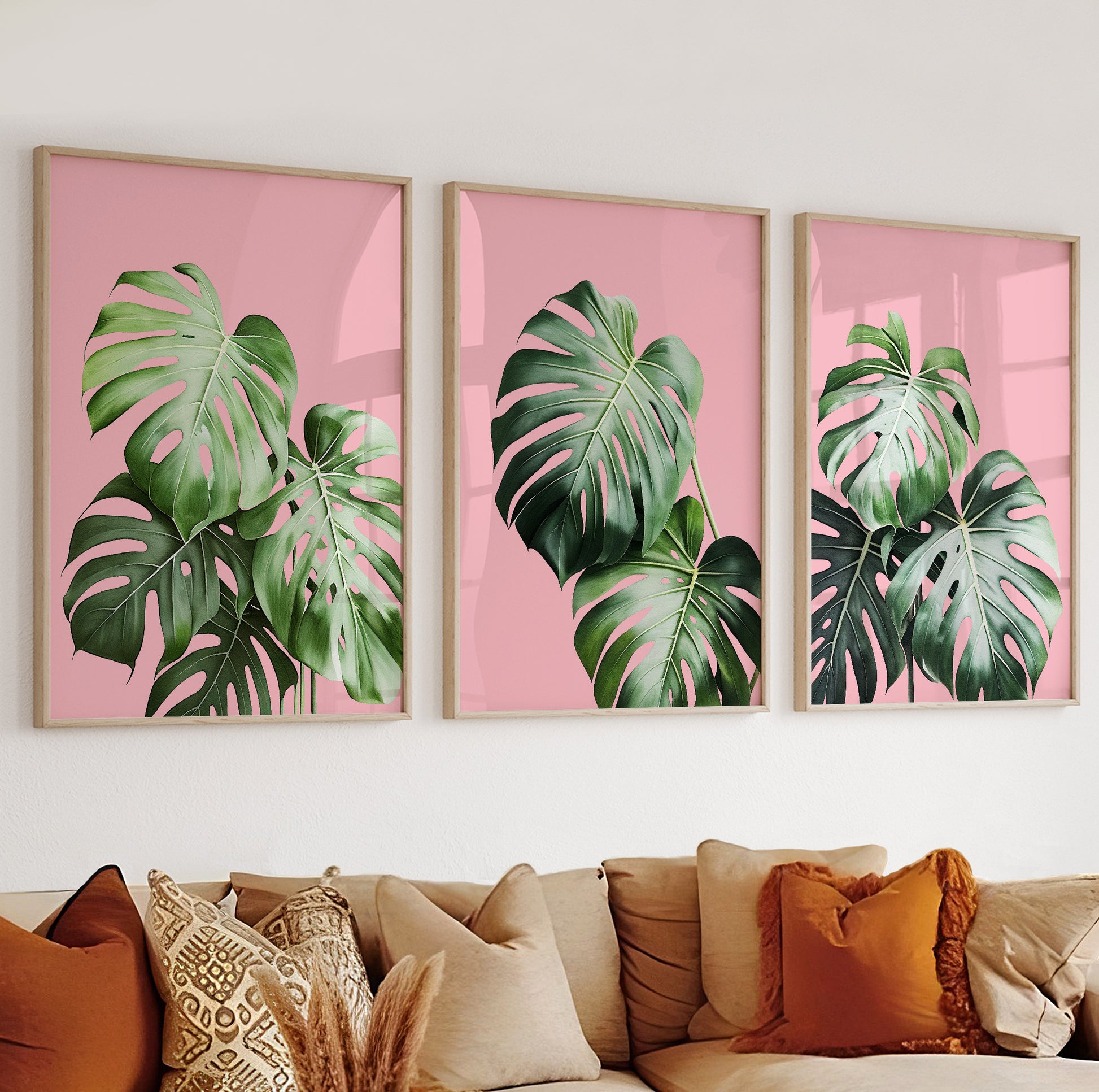Bright central poster with detailed monstera foliage set against a solid pink background.

