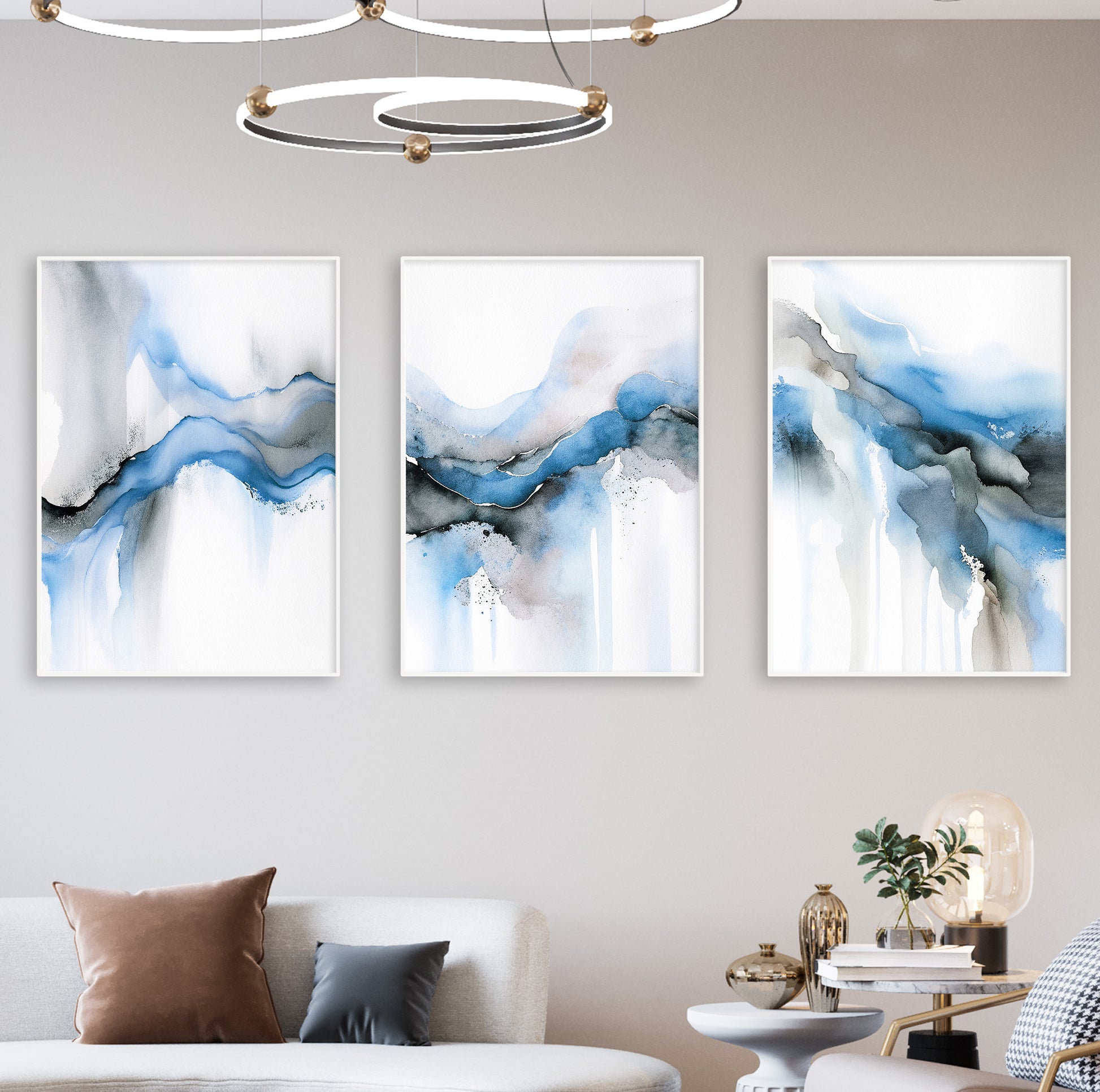 Three abstract art prints reflecting the movement of water in light blues and smoky greys.

