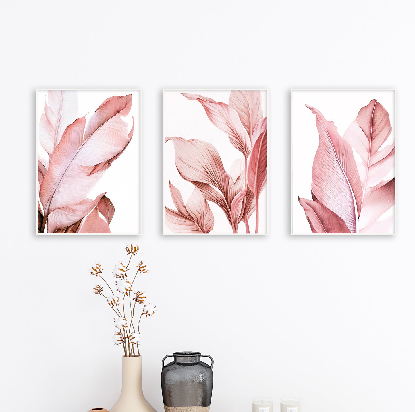 Decorative trio of pink botanical prints displayed over a white bed in a calm, naturally lit bedroom.

